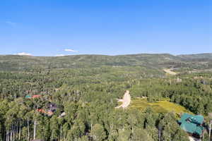 View of property location featuring a forest and a mountainous background