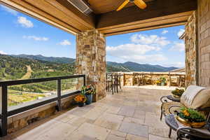 View of patio with a mountain view and a ceiling fan