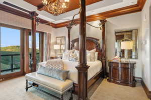Bedroom with access to exterior, wood ceiling, a tray ceiling, crown molding, and a chandelier