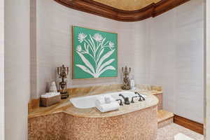Full bath with wallpapered walls and a bath