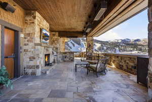 View of patio featuring an outdoor stone fireplace, outdoor dining space, and exterior kitchen