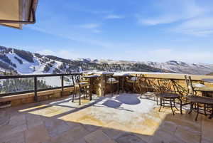 Snow covered patio with a patio and a mountain view