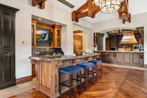 Bar featuring beamed ceiling, arched walkways, decorative backsplash, premium range hood, and recessed lighting