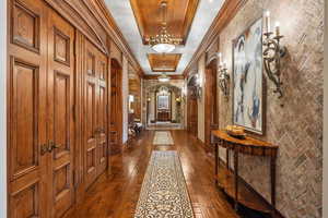 Hallway featuring ornamental molding, arched walkways, and dark wood finished floors