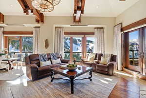Living area with healthy amount of natural light, recessed lighting, beam ceiling, and hardwood / wood-style flooring