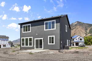 Back of house with a mountain view and stucco siding