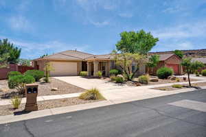 Single story home featuring a garage, a tiled roof, driveway, and stucco siding