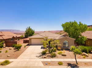 View of front of property featuring stucco siding, an attached garage, driveway, and a tiled roof