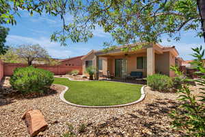 Back of house featuring a ceiling fan, stucco siding, and a fenced backyard