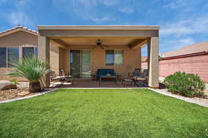 Back of property featuring ceiling fan, stucco siding, outdoor lounge area, and a patio area