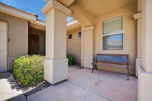 View of exterior entry with stucco siding and a patio area