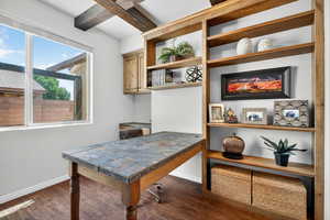 Office area with dark wood finished floors and beamed ceiling