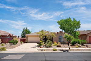 View of front of home featuring a garage, a tile roof, concrete driveway, and stucco siding