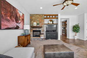 Living area featuring a fireplace, a ceiling fan, a textured ceiling, and recessed lighting