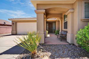 Property entrance featuring a garage, stucco siding, and concrete driveway