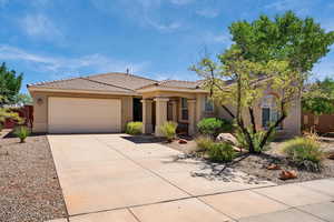 View of front of house with a garage, driveway, stucco siding, and a tile roof