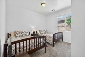 Carpeted bedroom featuring a textured ceiling and baseboards