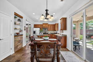 Dining room with a chandelier, dark stone finish floors, and recessed lighting