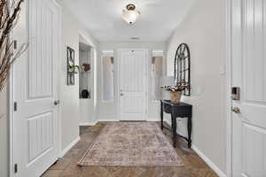 Entrance foyer featuring stone finish floors and a textured ceiling