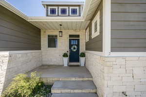 View of exterior entry featuring covered porch