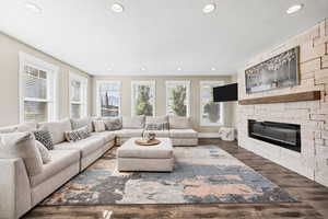 Living area featuring wood finished floors, recessed lighting, and a fireplace