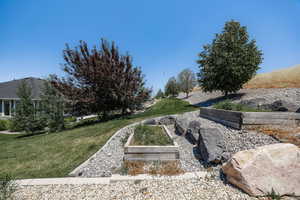 View of grassy yard with a vegetable garden