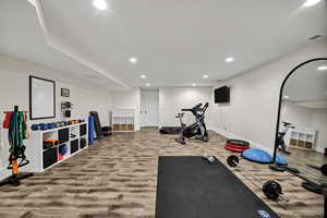 Exercise room with recessed lighting and wood finished floors