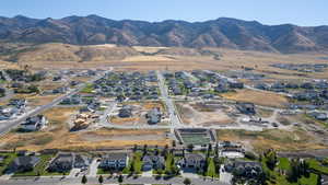 Aerial view of property and surrounding area with nearby suburban area and a mountain backdrop