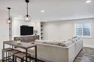Living room with recessed lighting and dark wood-type flooring