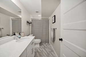 Full bathroom with vanity, light marble finish flooring, curtained shower, and recessed lighting