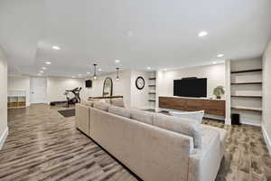 Living room featuring recessed lighting, light wood finished floors, and built in shelves