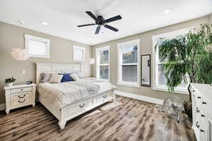Bedroom featuring multiple windows, dark wood finished floors, ceiling fan, and recessed lighting