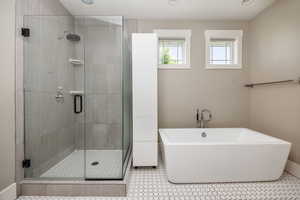 Bathroom featuring a shower stall, a soaking tub, and recessed lighting
