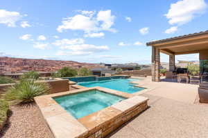 Outdoor pool with an in-ground hot tub, a patio, outdoor dining area, and a mountain view