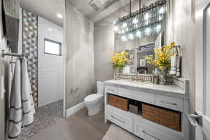 Bathroom with walk in shower, vanity, tile patterned floors, and recessed lighting