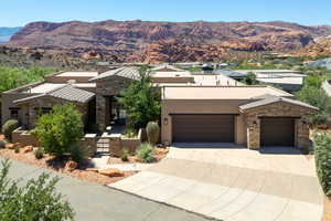 View of front of home with stucco siding, a gate, and a mountain view