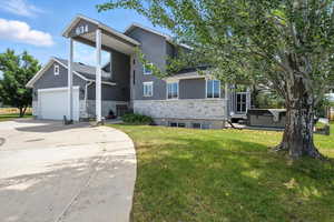 View of front of property featuring stone siding, stucco siding, and a front lawn