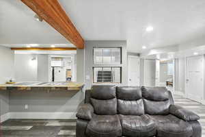 Living room featuring wood finished floors, recessed lighting, a textured ceiling, and beamed ceiling