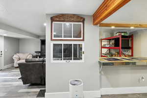 Detailed view of recessed lighting, wood finished floors, a textured ceiling, and beam ceiling