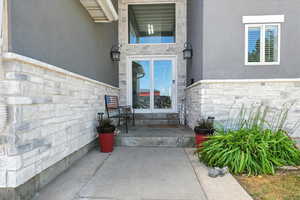 Entrance to property with stone siding and stucco siding
