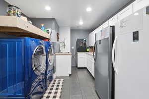 Washroom with washing machine and clothes dryer and a sink