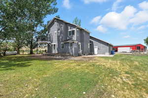 Back of property featuring stucco siding, a yard, and a balcony