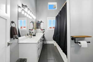 Full bath featuring vanity and baseboards