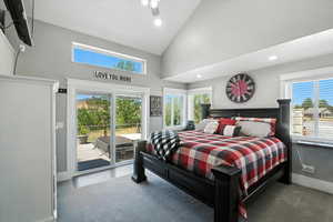 Carpeted bedroom featuring access to outside, high vaulted ceiling, multiple windows, and recessed lighting