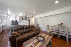 Living room with ornamental molding, dark wood-style floors, and recessed lighting