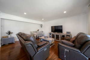 Living area featuring crown molding, wood finished floors, and recessed lighting