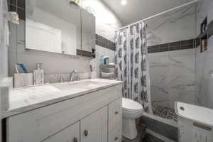 Full bath featuring vanity and tiled shower