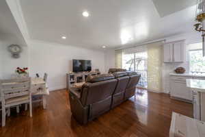 Living room featuring crown molding, dark wood finished floors, and recessed lighting