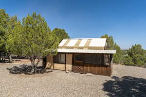 View of front facade with metal roof and an outdoor structure
