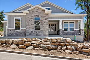 Craftsman-style house featuring board and batten siding, stone siding, and a porch